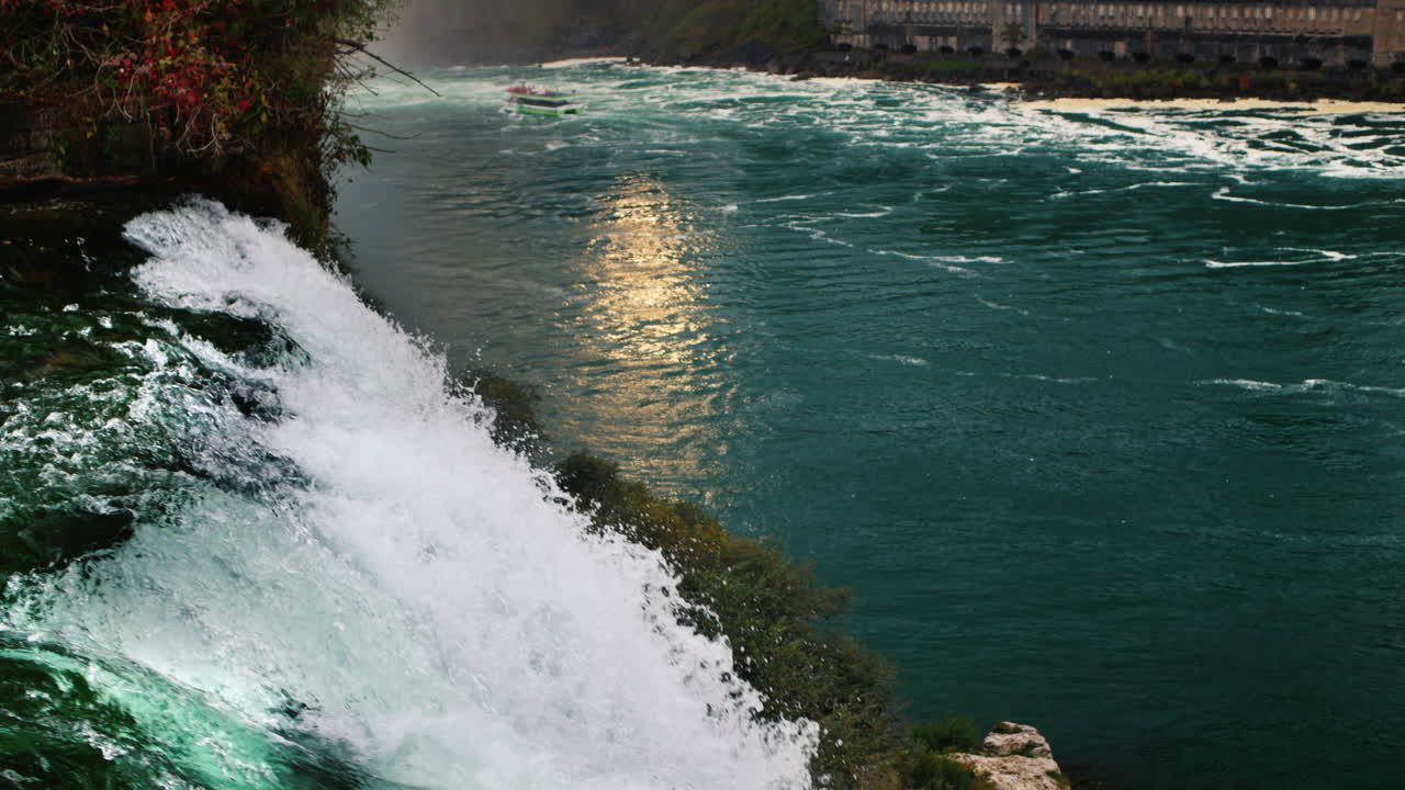 나이아가라 폭포의 저녁. 강은 해가 지는 것을 반영하고, 전면에는 강력한 물줄기가 있습니다. 슬로우 모션 120fps 비디오