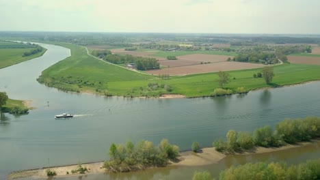 aerial drone view of the beautiful river in the netherlands and a boat is passing on the scene