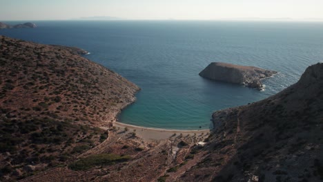 aerial panoramic overview of syros greece beach and calm ocean waves entering varvarousa, stunning blue water