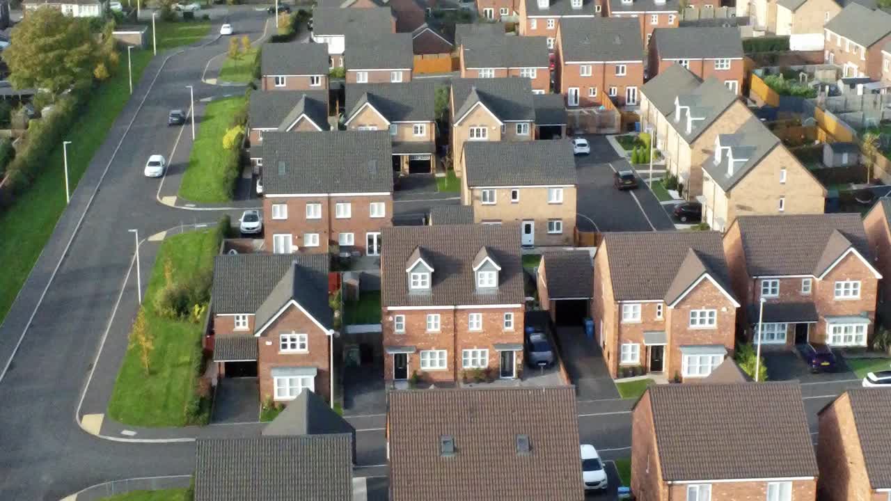 Property ladder new British housing estate aerial view overlooking rooftops descending birdseye tilt up