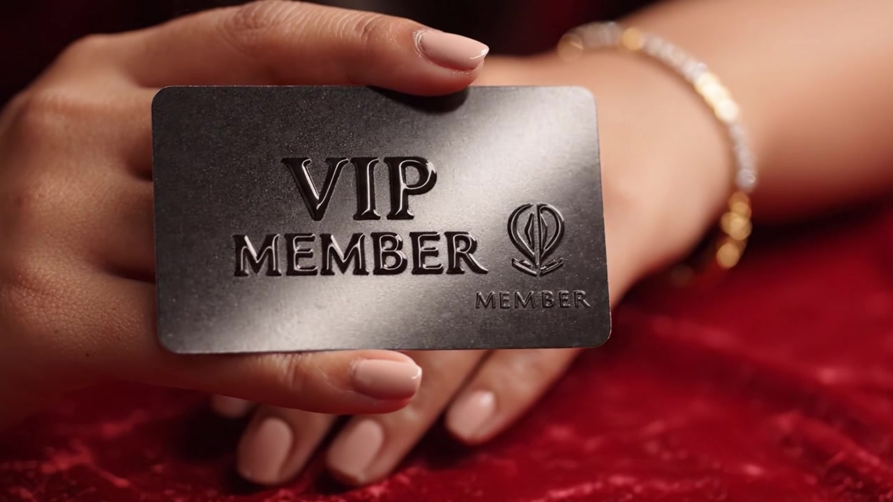 Mostrando una elegante tarjeta de membresía VIP negra sostenida con gracia, enfatizando el lujo y la exclusividad en un entorno glamuroso.