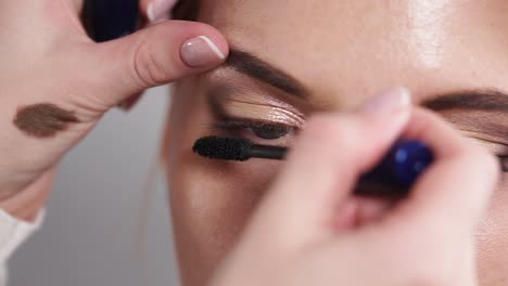 applying mascara and eyebrow makeup