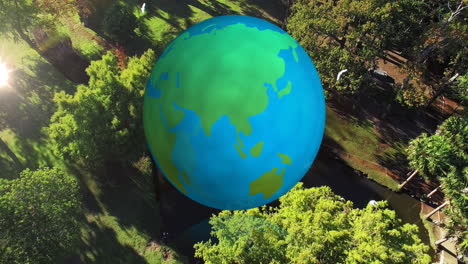 animation of spinning globe over landscape and birds