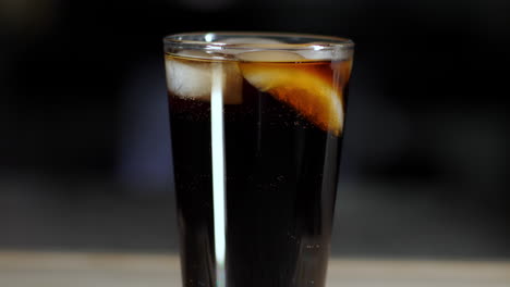 burbujas gaseosas de soda subiendo en un vaso de pinta con hielo