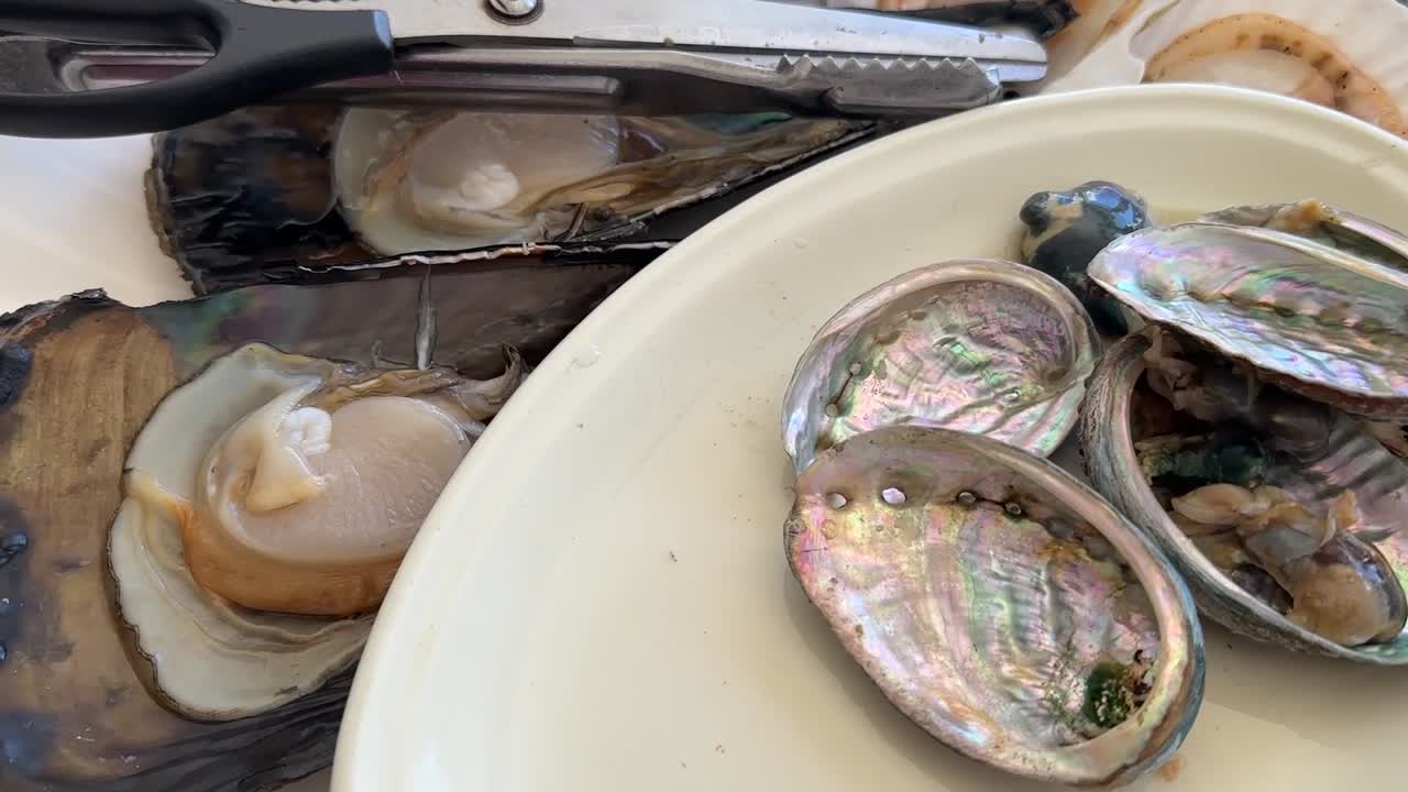 Famous seafood restaurant in Haeundae Beach, Busan, South Korea. Fresh assorted shellfish cooking over a traditional charcoal bbq grill