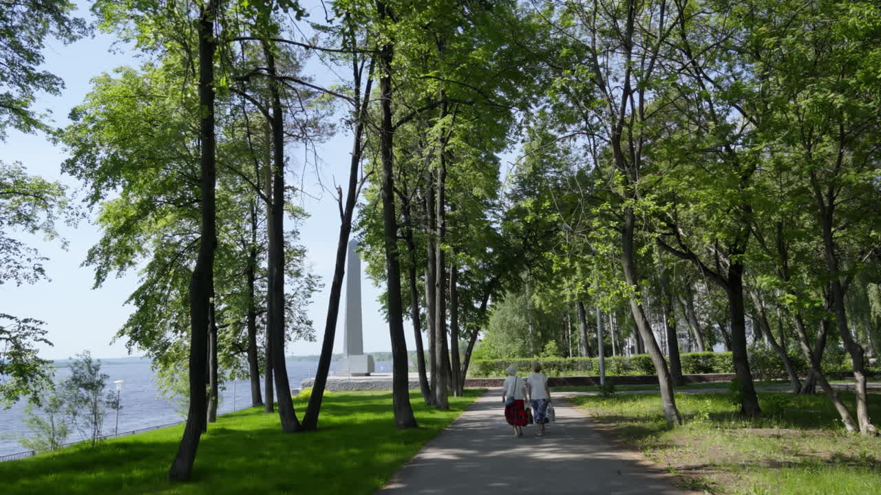 una pareja de ancianos caminando en un parque junto al río
