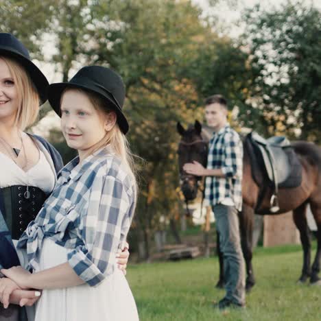 madre e hija con un joven con un caballo