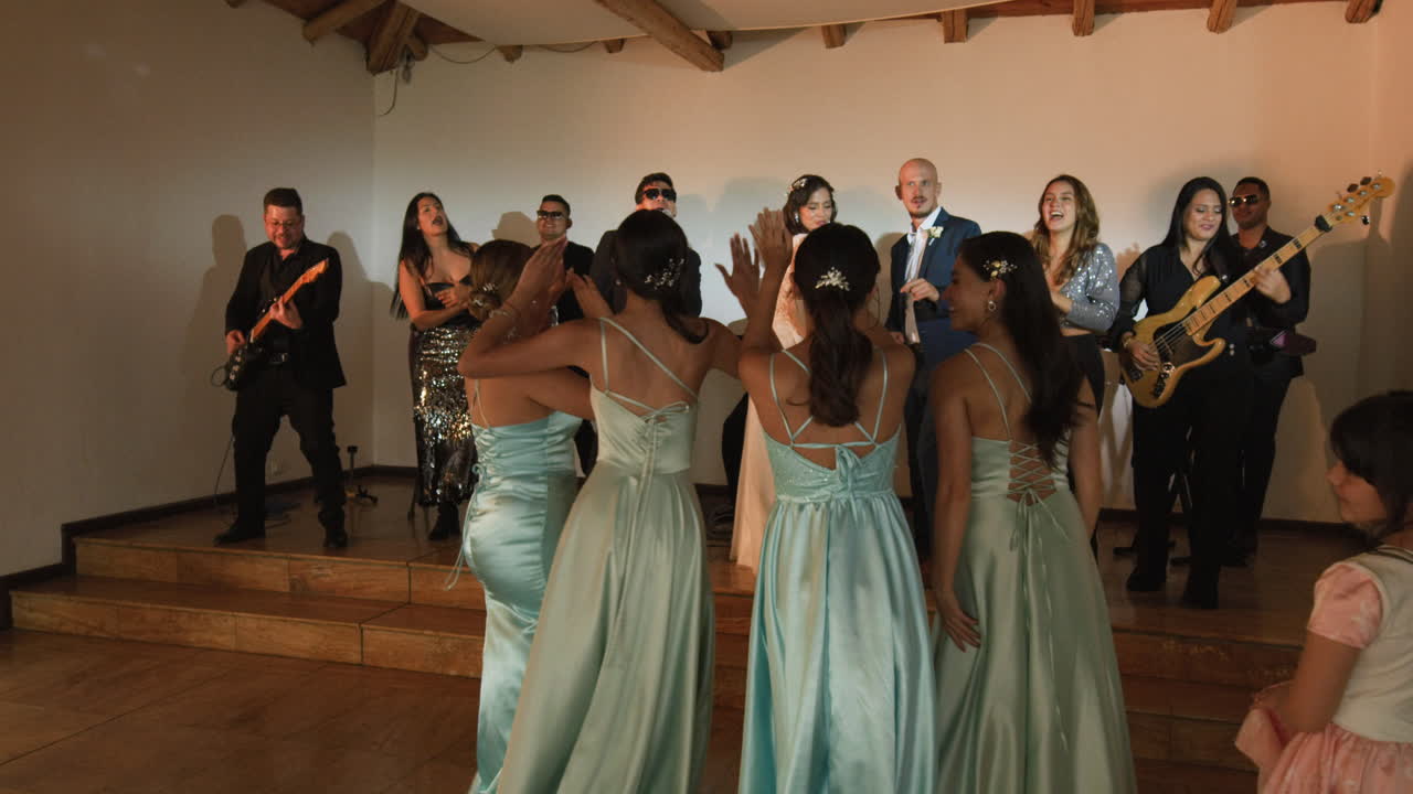 Clip of a wedding where the newlyweds dance happily with their guests and bridesmaids.