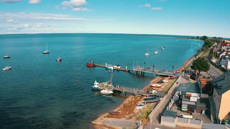 drone flying above rewa towards the baltic sea with pier in the background