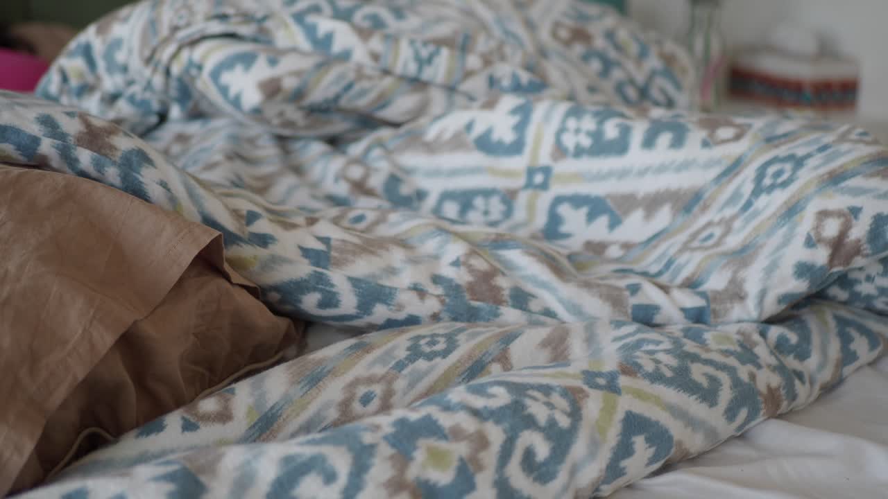 패턴 시트 와 베개 를 가진 침대 의 근처