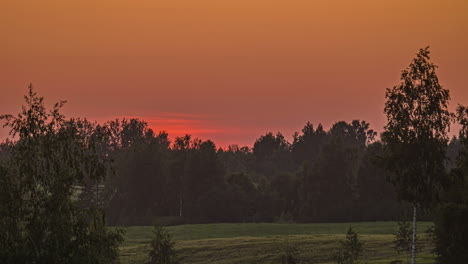 Paisaje-De-Campo-Con-árboles-Densos-Y-Prados-Verdes-Contra-El-Cielo-De-La-Puesta-De-Sol-Ardiente