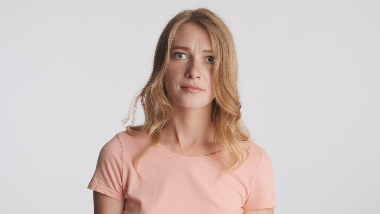 una mujer caucásica saludando no con la cabeza en la cámara.