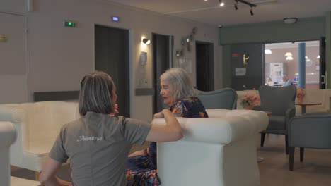 un cuidador en un hogar de ancianos se acerca a un residente para hablar de una preocupación
