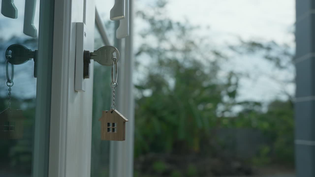 casa lista para vivir y contrato de acuerdo completo. venta de casa, alquiler y compra concepto. la llave de la casa para desbloquear una casa nueva está conectada a la puerta. el llavero se movía mientras soplaba el viento.