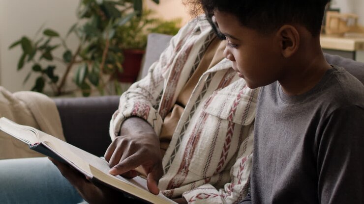 Father and son reading in the sofa