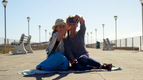 Siblings-taking-selfie-with-mobile-phone-at-beach-4k