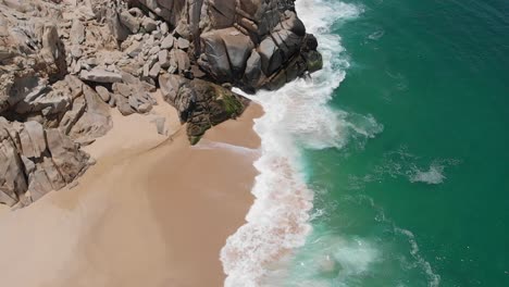 aerial view of waves crashing on shore by rock formation