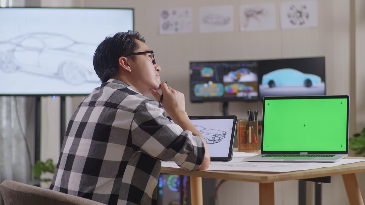 아시아 남성이 테이블릿과 그린 스크린 노트북 에서 자동차 컨셉에 대해 생각하고 tv와 컴퓨터 디스플레이 3d 전기 자동차 모델과 함께 스튜디오에서 지표손가락을 올리고 있습니다.