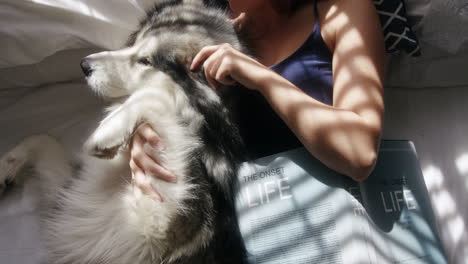 woman and dog relaxing in bed