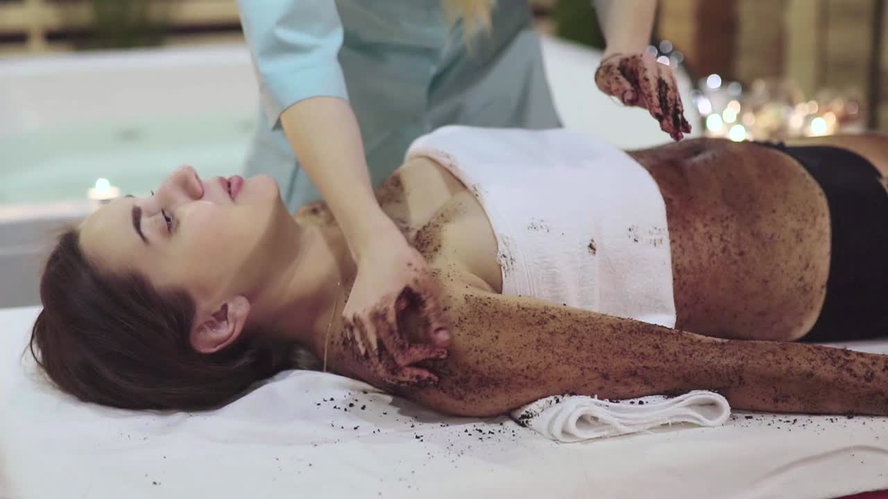 Woman receiving a body scrub spa treatment