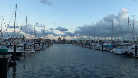 marina with moored yachts and small boats at dusk