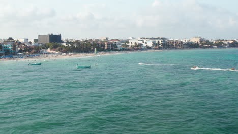 Motos-De-Agua-Navegando-Hacia-La-Playa-En-Playa-Del-Carmen,-México.-Vista-Aérea-Con-La-Playa-De-Arena-Y-El-Mar-Caribe