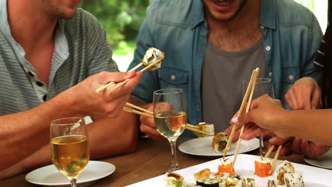 happy friends eating sushi