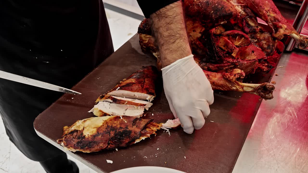 Local Egyptian chef preparing food by hand slicing chicken in restaurant kitchen, traditional cooking process