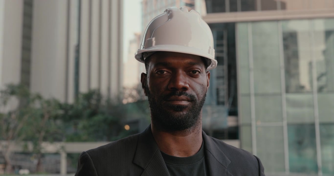 Retrato de un ingeniero profesional con sombrero en la ciudad.