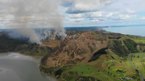 Vista-Aérea-Del-Humo-De-Un-Incendio-Forestal-Que-Se-Eleva-Contra-El-Telón-De-Fondo-De-Un-Pintoresco-Paisaje-Costero