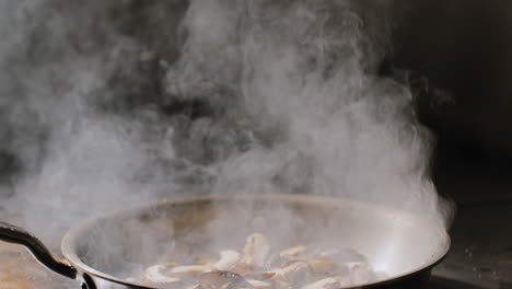 mushrooms being sautéed in a hot pan