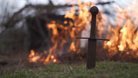 espada de metal frente a un fuego ardiente, concepto de mediana edad, fuego fuerte en el fondo