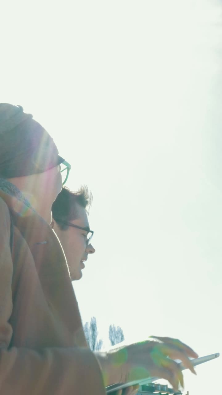 People looking at a tablet in the sun