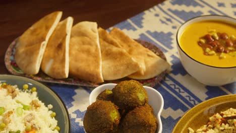 arabian cuisine. bulgur with eggplant, falafel, bean soup on table, couscous with chicken. traditional middle eastern culture. moutabal and vegetable salad in bowls, pita. delicious rice with meat