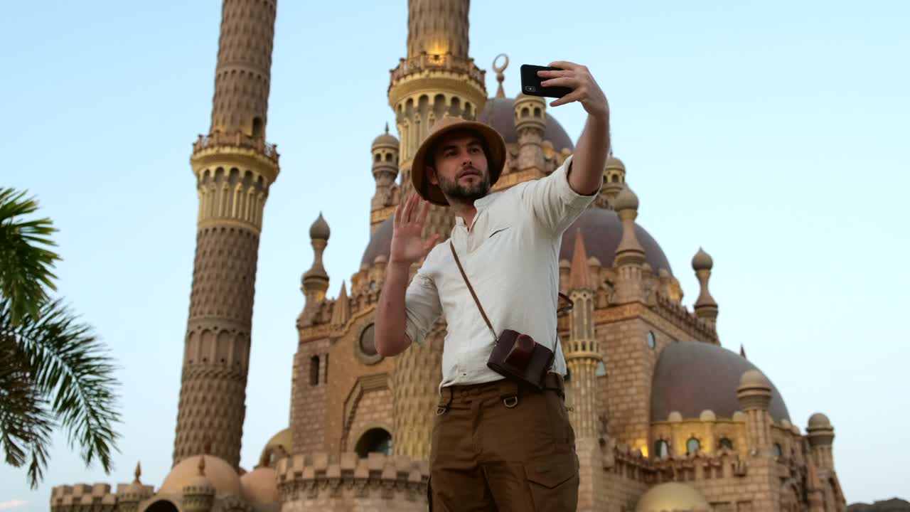 un hombre se toma una selfie en el teléfono en el mercado de la ciudad vieja en la mezquita de el cairo.