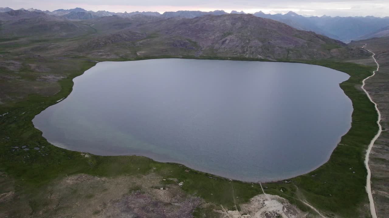 Sheosar Lake surrounded by summer campers and mountains in Deosai National Park. Gilgit-Baltistan, Pakistan
