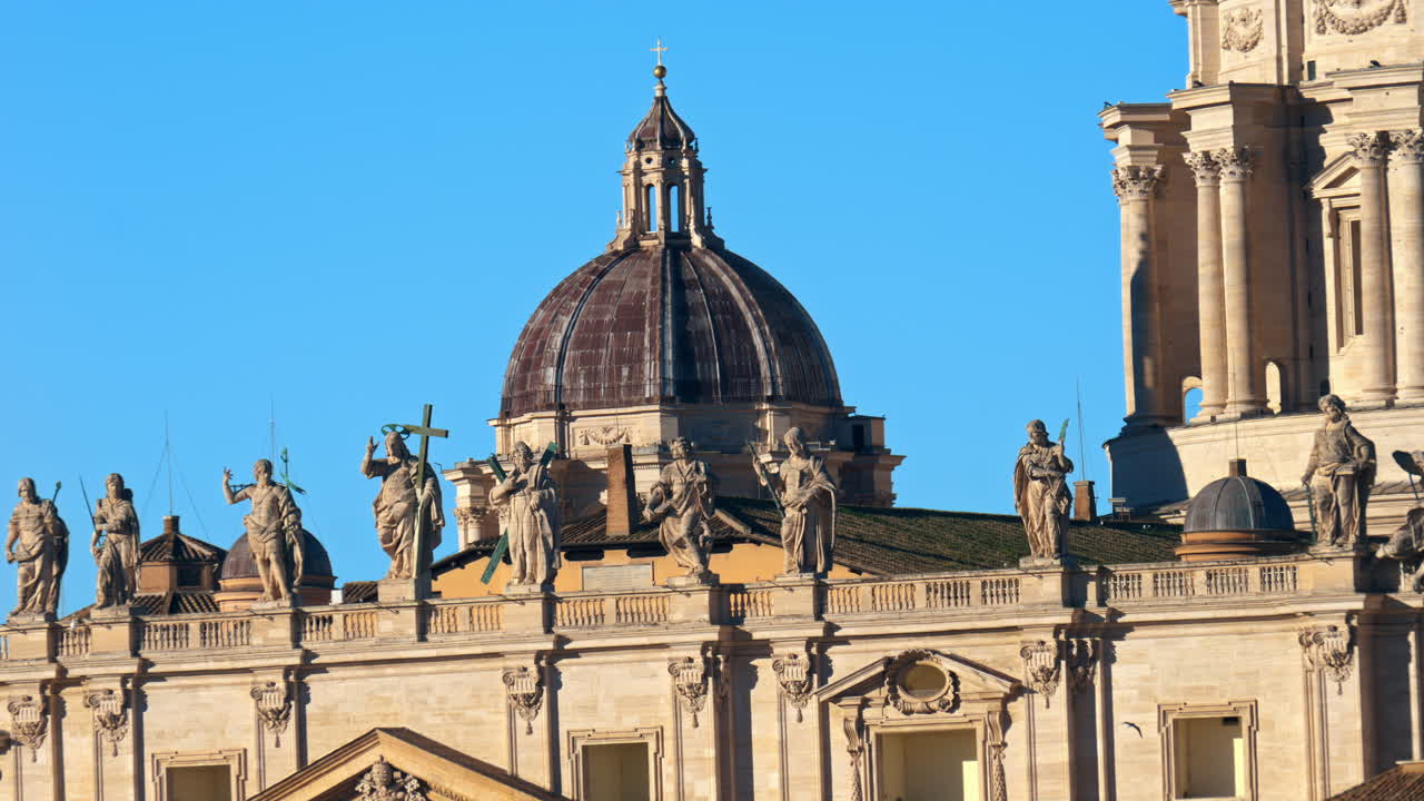 Statues on Saint Peter's Basilica at sunset in Rome, Italy