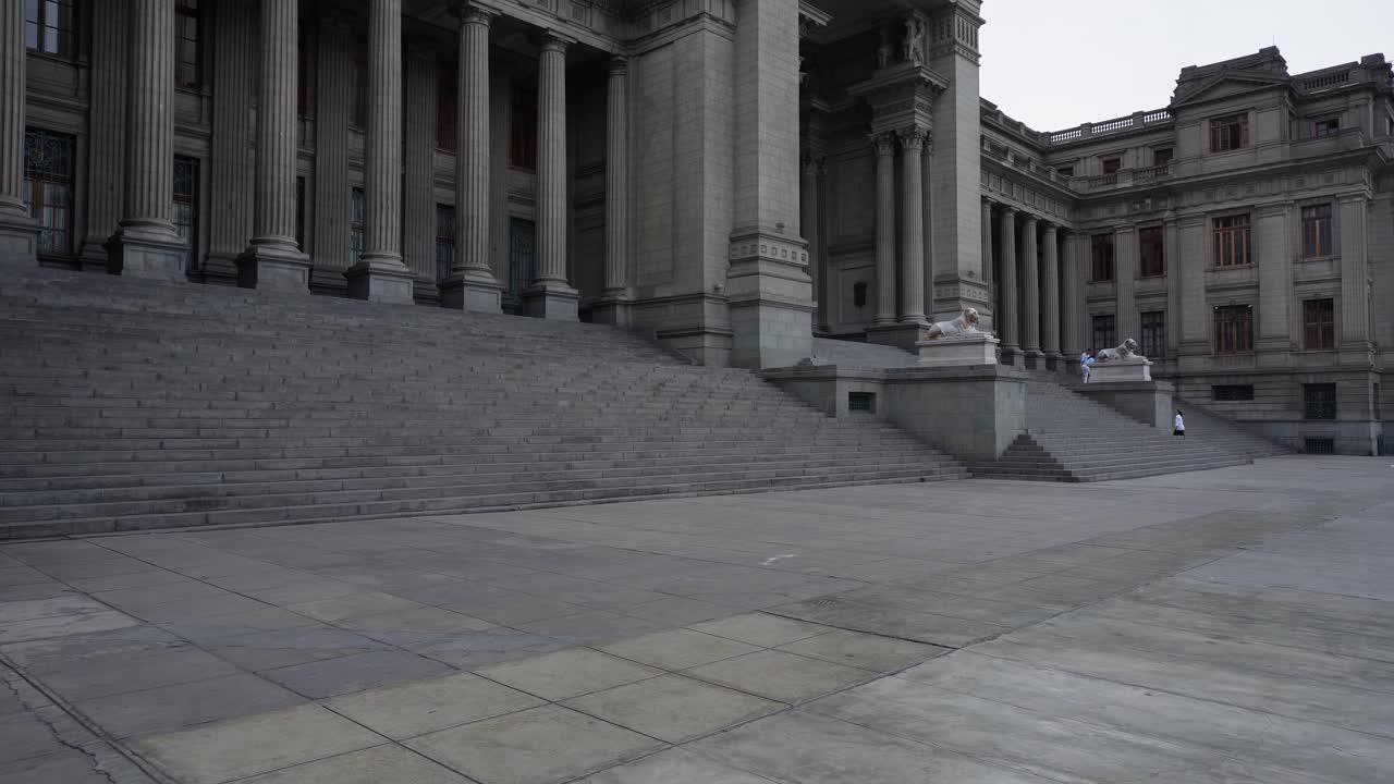 Camera slowly tilts up revealing a neoclassical building called "Palacio de Justicia" which is the seat of the supreme court of Peru. It's located in Lima, Peru