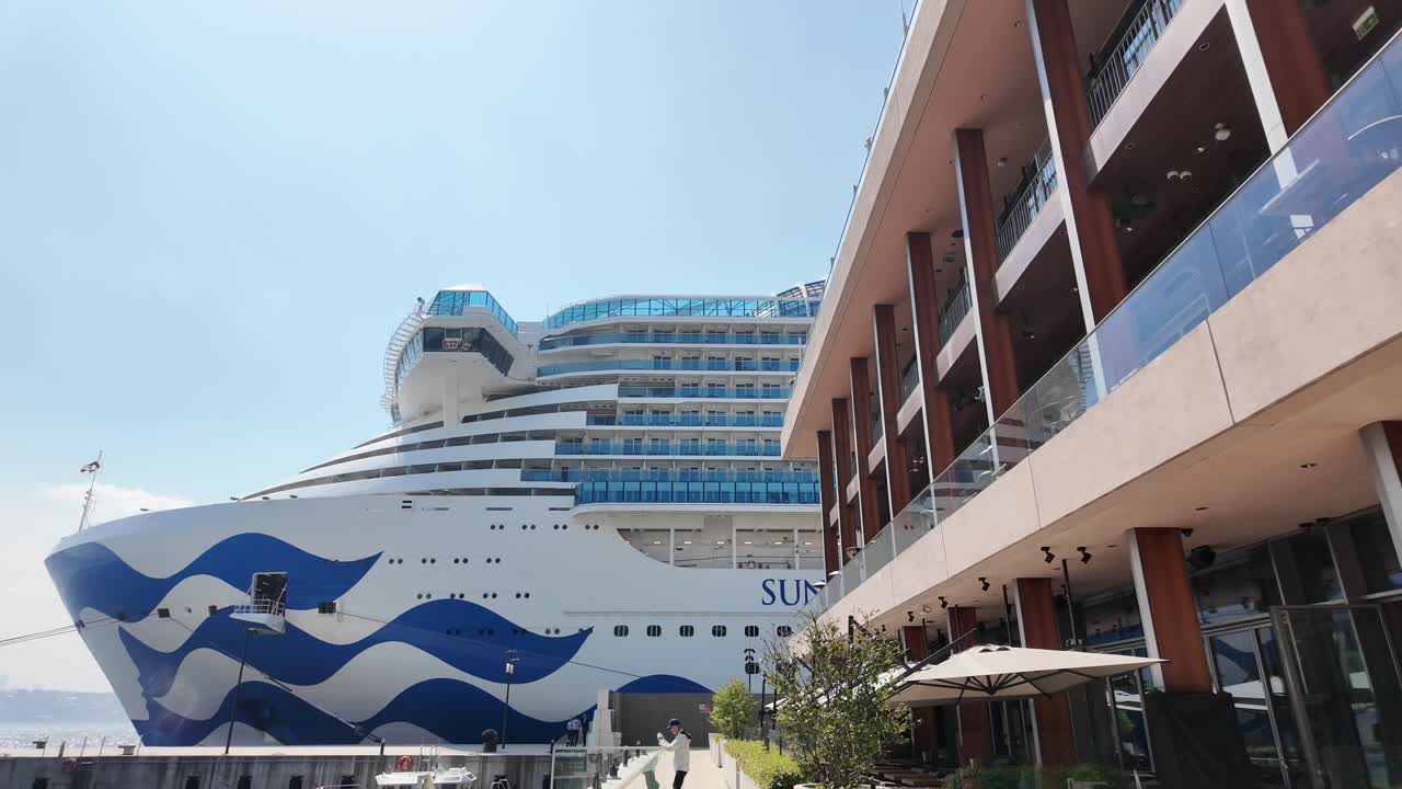 Cruise Ship at Waterfront City Pier with Modern Building and Outdoor Seating