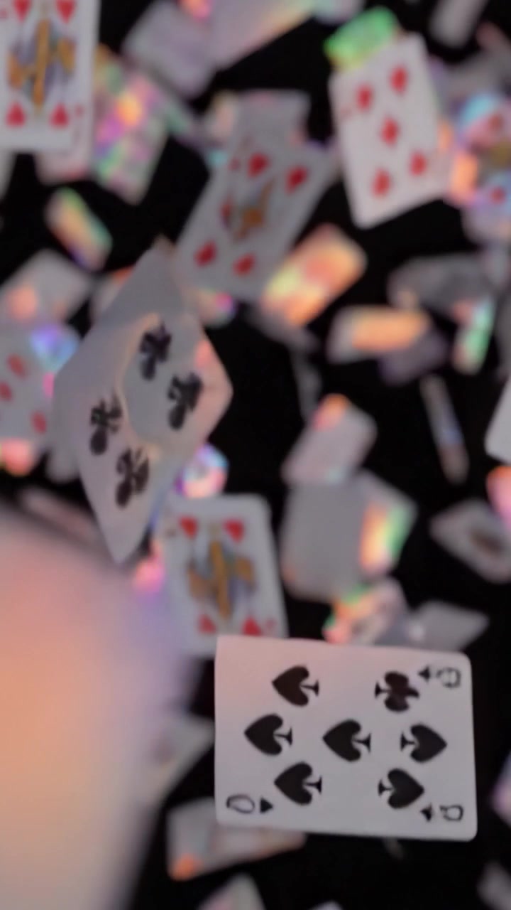 Una mostra accattivante di carte da gioco che cadono a cascata nell'aria contro uno sfondo scuro, mettendo in mostra colori vivaci e design unici in movimento.