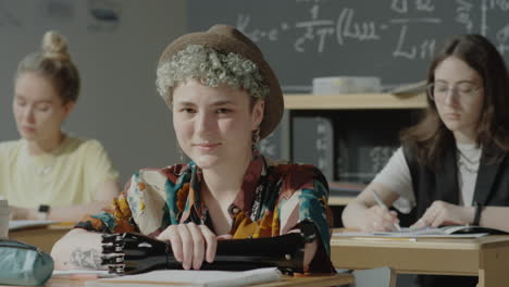 student with prosthetic arm smiling in classroom