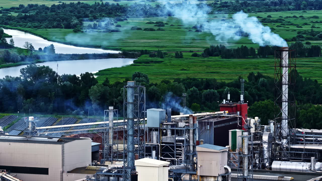Drone footage of industrial smoke polluting a green landscape