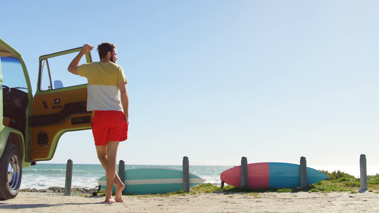 vista trasera de un hombre apoyado en la puerta de la furgoneta 4k