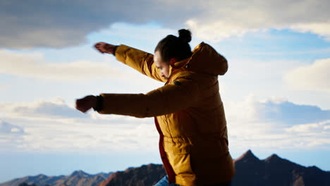 victorious adventurer celebrates on top of a mountain and dancing