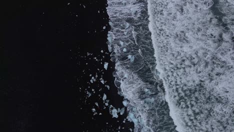 waves breaking on black sandy lagoon at diamond beach, iceland