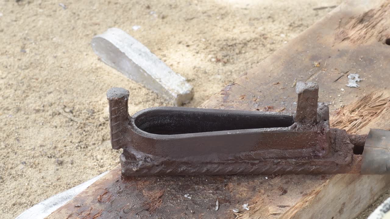 녹은 금속이 모래 땅 위에 이로 아지는 모습, 근접 촬영