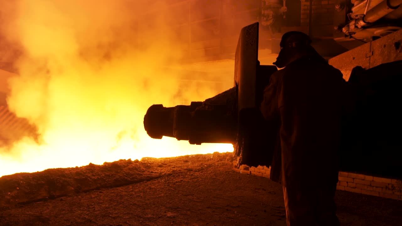 Operaio siderurgico che aziona un forno