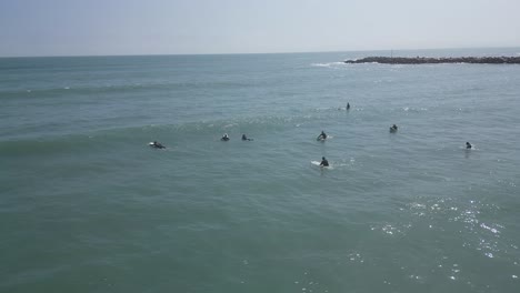 aerial slow panning shot of surfers and swimmers