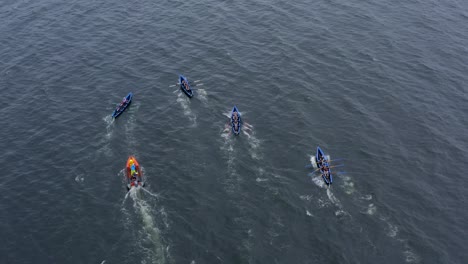 Athletes-and-support-crew-quickly-row-currach-boats-in-open-ocean