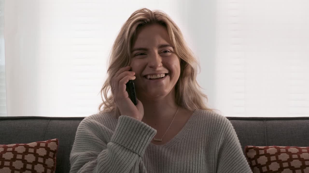 Attractive young woman smiling and laughing on a phone conversation
